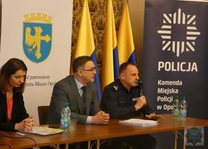 '
Na zdjęciu przy stole konferencyjnym od lewej: 
Dorota Rudkowska Naczelnik Wydziału Polityki Społecznej Urzędu Miasta Opola,
 Zastępca Prezydenta Miasta Opola Przemysław Zych 
i Komendant Miejski Policji w Opolu podinsp. Rafał Drozdowski.