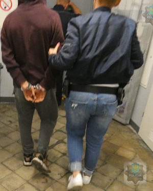 Policjant operacyjny  prowadzi podejrzanego