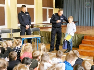 Komendant miejski wręcza nagrodę uczniowi klasy drugiej