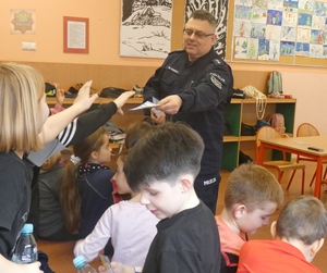 Policyjny profilaktyk asp. sztab. Maciej Kędra rozmawia z uczestnikami półkolonii