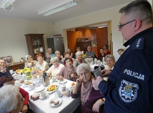 policjant z KMP Opole rozmawia z seniorami o poszukiwaniach osób zaginionych na pograniczu polsko- czeskim. Działania w ramach projektu.