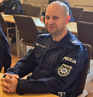 Zdjęcie przedstawia policjanta z naszywką &quot;Ratownik&quot;.