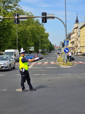 policjant na skrzyżowaniu kierunkuje ruchem