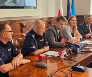 Komendant Wojewódzki Policji w Opolu oraz Komendant Miejski Policji w Opolu, w umundurowaniu, i przedstawiciele władz miasta podczas podpisywania umowy na przekazanie dotacji