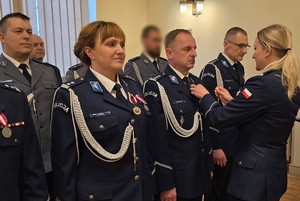 Zdjęcie przedstawia policjantów w trakcie uroczystej zbiórki podczas wręczania medali.