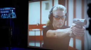 Policjantka z bronią na ekranie.
