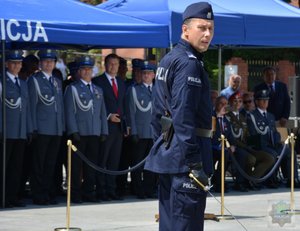 policjanci z Katowic podczas pokazu musztry paradnej: maszerują z bronią, kucają, podrzucają bronią, ich dowódca w dłoni trzyma szablę