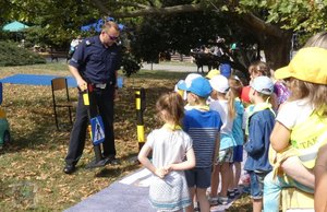 na pikniku policyjnym: dzieci biorą udział w kole fortuny - konkursie z nagrodami - policjant-rycerz pokazuje zbroje, policjant-malarz pokazuje swoje obrazy, komandosi policyjni prezentują uzbrojenie