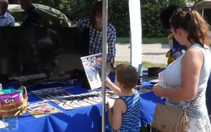 na pikniku policyjnym: dzieci biorą udział w kole fortuny - konkursie z nagrodami - policjant-rycerz pokazuje zbroje, policjant-malarz pokazuje swoje obrazy, komandosi policyjni prezentują uzbrojenie