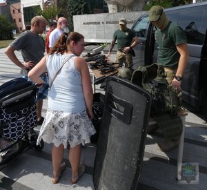 na pikniku policyjnym: dzieci biorą udział w kole fortuny - konkursie z nagrodami - policjant-rycerz pokazuje zbroje, policjant-malarz pokazuje swoje obrazy, komandosi policyjni prezentują uzbrojenie