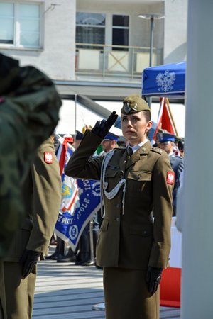 Pani żołnierz oddaje honor fladze państwowej